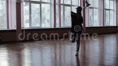 一位女专业舞蹈演员在舞蹈室表演，舞蹈女孩的黑暗剪影